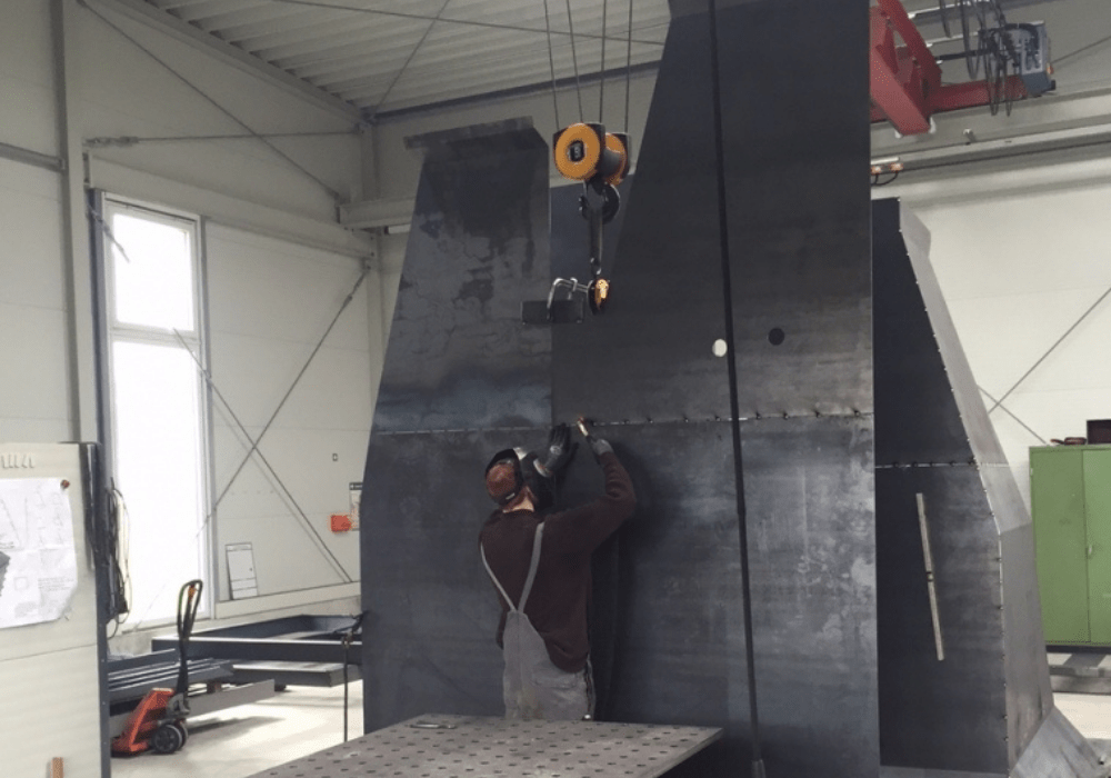 Mitarbeiter schweißt massive Metallelemente bei HB Fertigungs GmbH in Stuhr