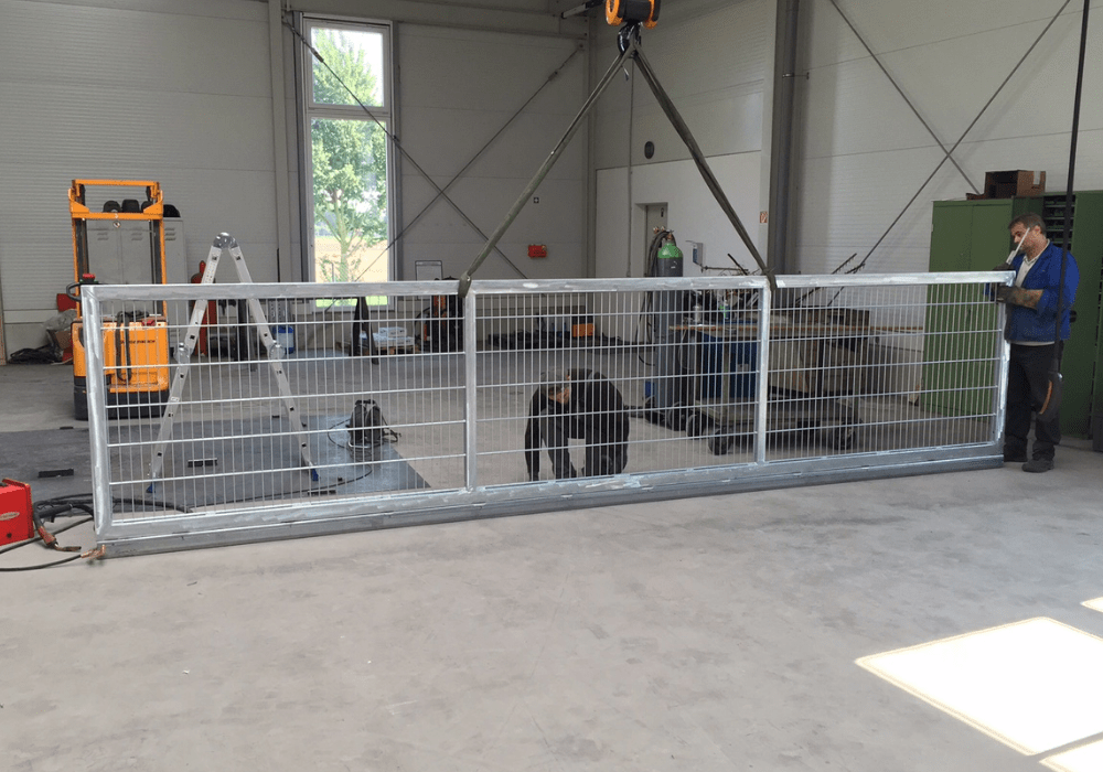 Montage eines Schutzzaunsystems aus Metall in einer Werkhalle von HB Fertigungs GmbH